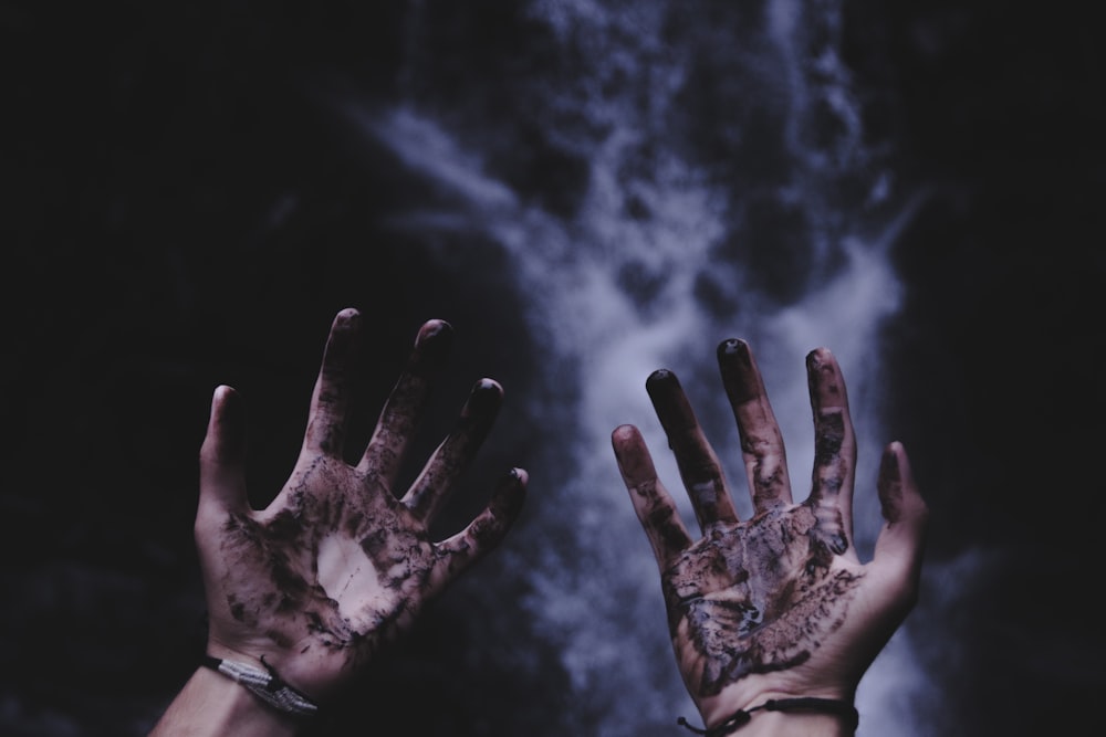 person hands with black liquids