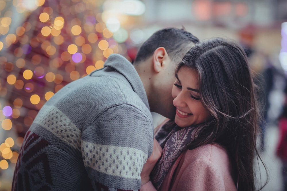 shallow photography of man hugging woman outdoors