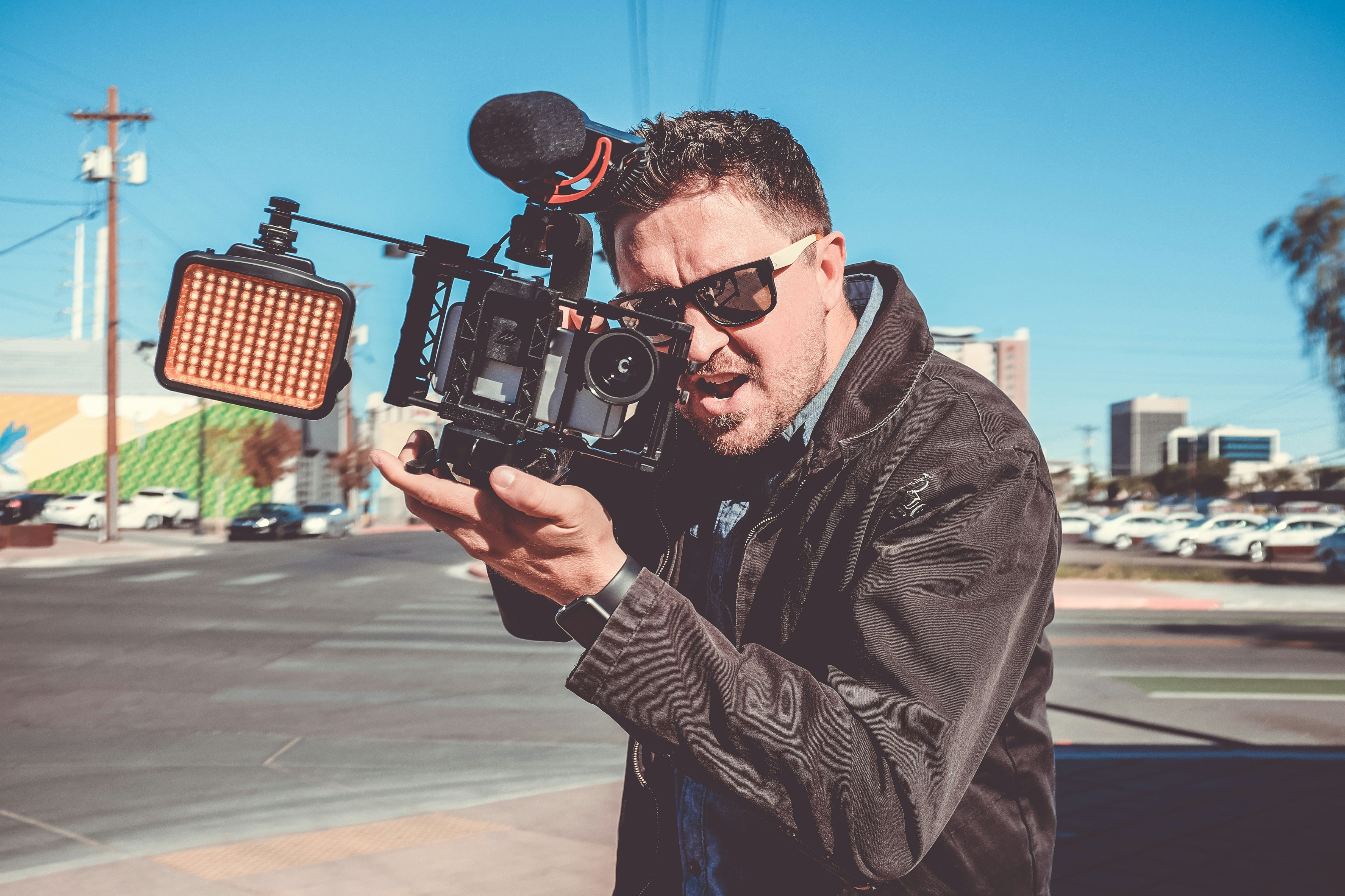 shallow focus photography of man holding video camera