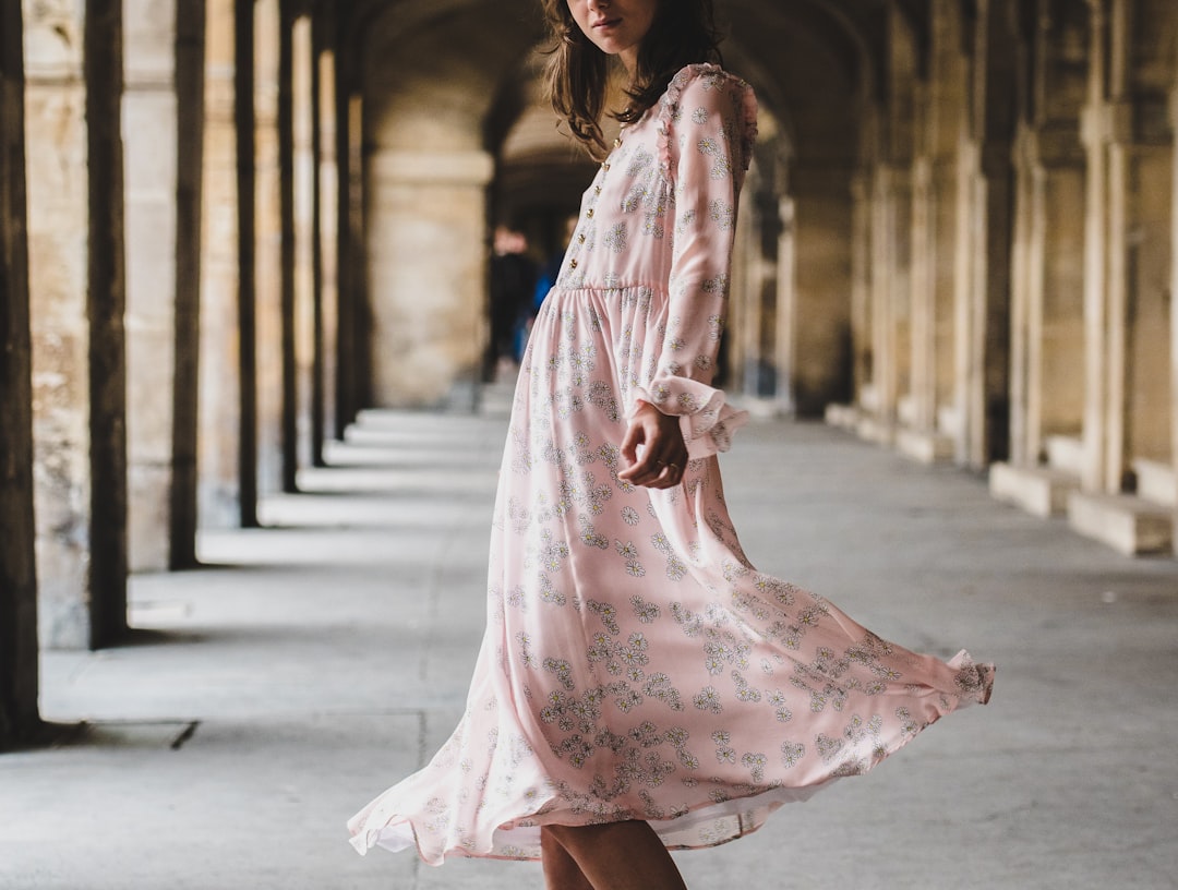 woman wearing pink long-sleeved dress standing inside building