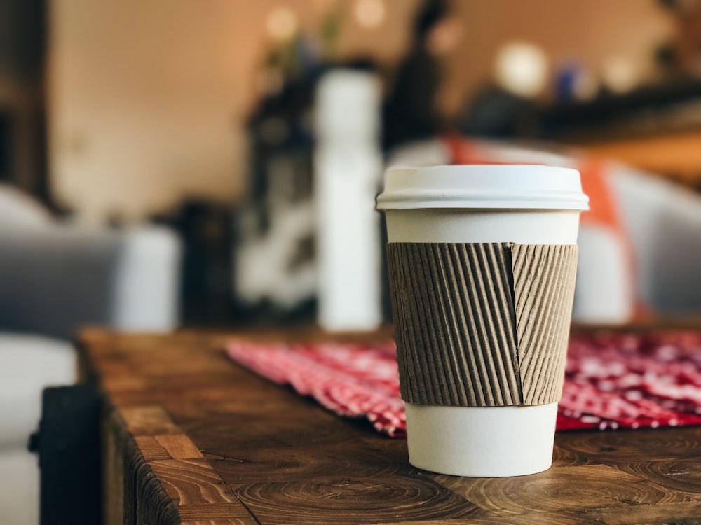 white plastic cup on brown surface