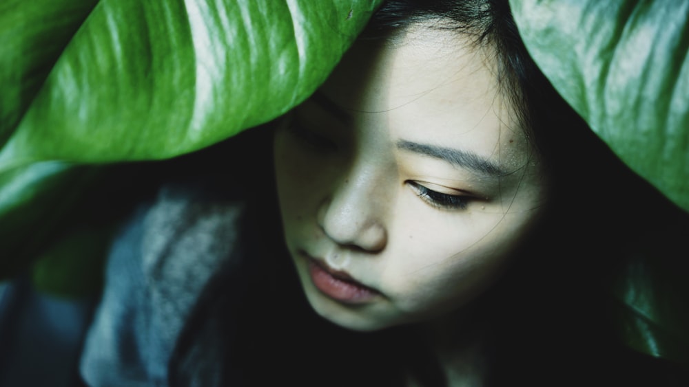 woman covering under green leafed plant