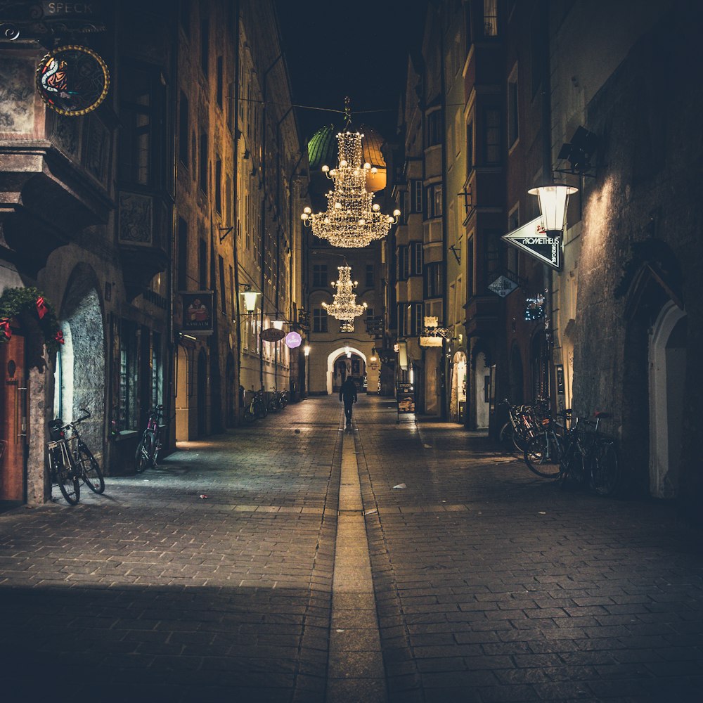 person walking on pathway showing lighted chandelier during night time