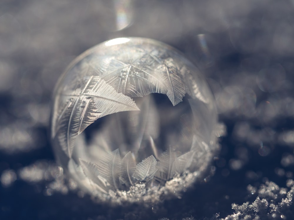 une boule de cristal avec quelques plumes à l’intérieur