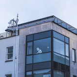 A Luminara Shield technician carefully inspecting a commercial building's entrance at dusk.