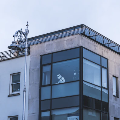 A Luminara Shield technician carefully inspecting a commercial building's entrance at dusk.
