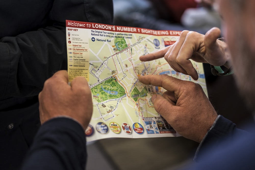 zwei Personen zeigen auf Londons Sightseeing-Karte Nummer eins