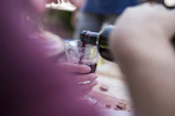Close-up of a sommelier pouring red wine into a glass at a Scandinavian-style restaurant.