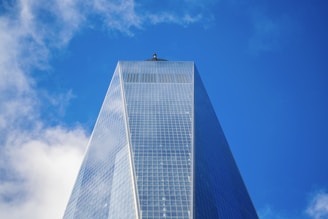 A towering Manhattan skyscraper reflecting the city skyline on a clear day.