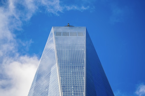 A towering Manhattan skyscraper reflecting the city skyline on a clear day.