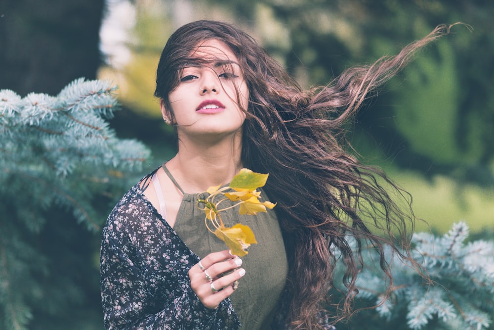 Mujer sosteniendo planta verde en fotografía de enfoque superficial