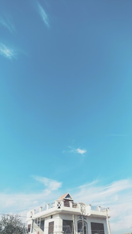 Contemporary exterior of a house painted in blue and white under a clear sky.