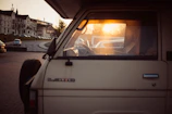 A comfortable Hasby Trans Jawa travel van parked at a busy city street during sunset