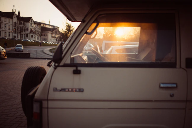 A comfortable Hasby Trans Jawa travel van parked at a busy city street during sunset