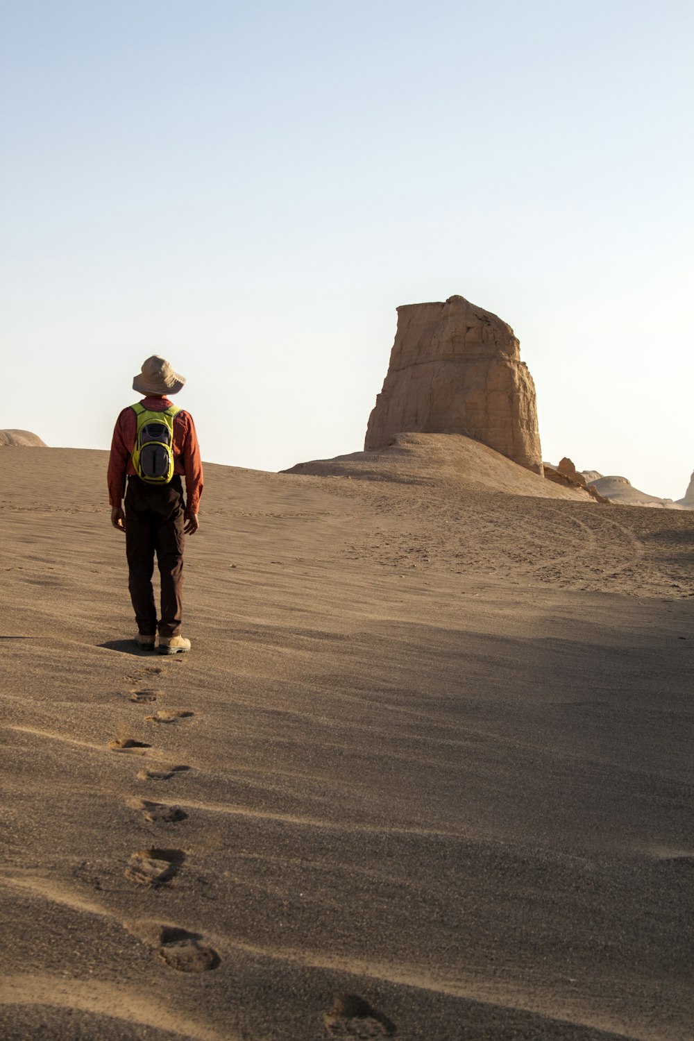 uomo che indossa il cappello che cammina sul deserto