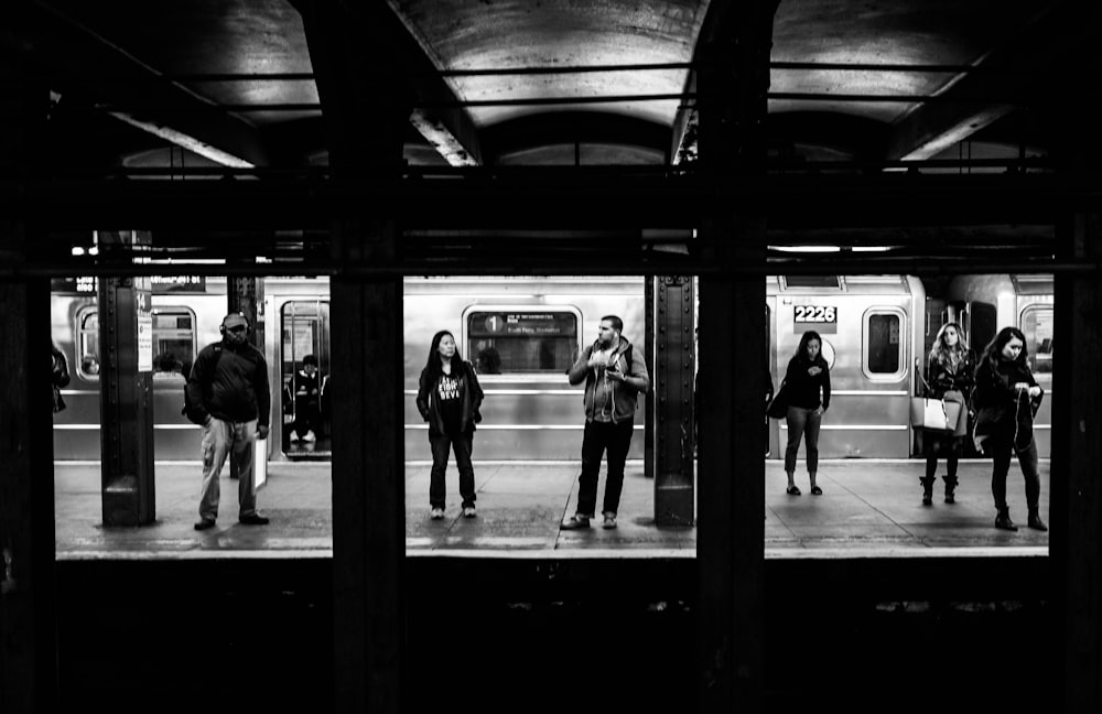 grayscale photography of crowd standing on the subway