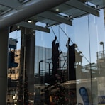 utility man standing in scissor platform cleaning glass window