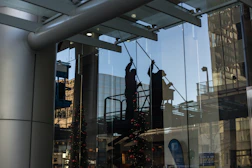 utility man standing in scissor platform cleaning glass window