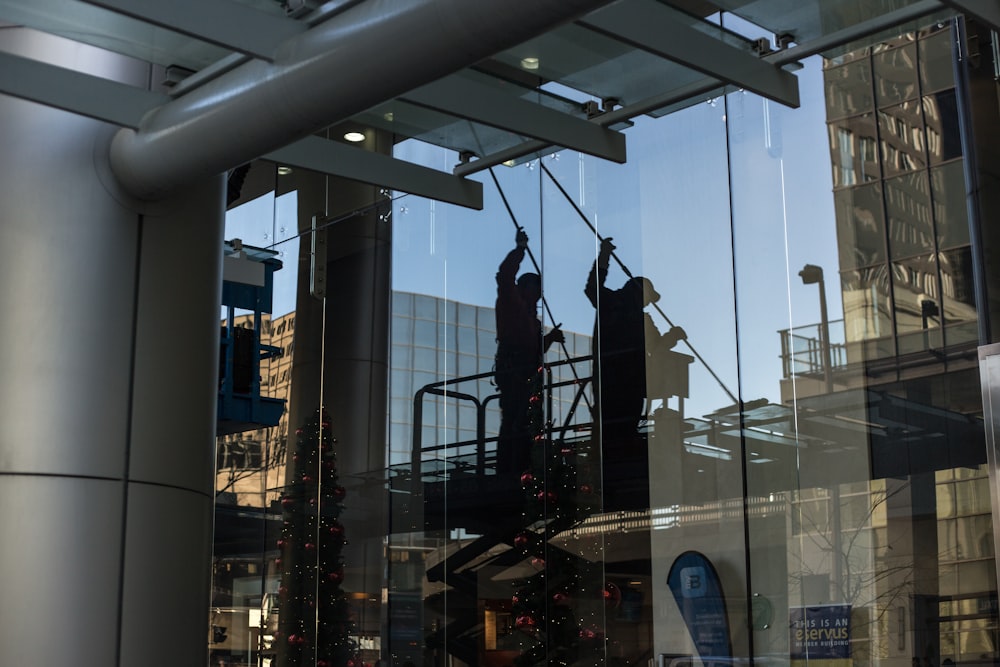 utilitario de pie en una plataforma de tijera limpiando la ventana de vidrio