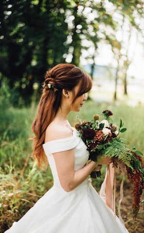 woman wearing white off-shoulder wedding gown wearing white petaled flower