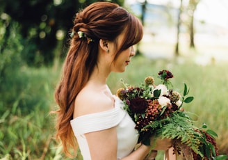 woman wearing white off-shoulder wedding gown wearing white petaled flower