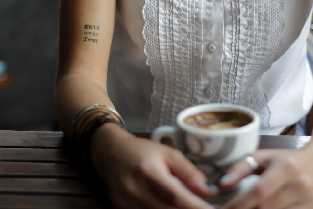 person holding ceramic teacup