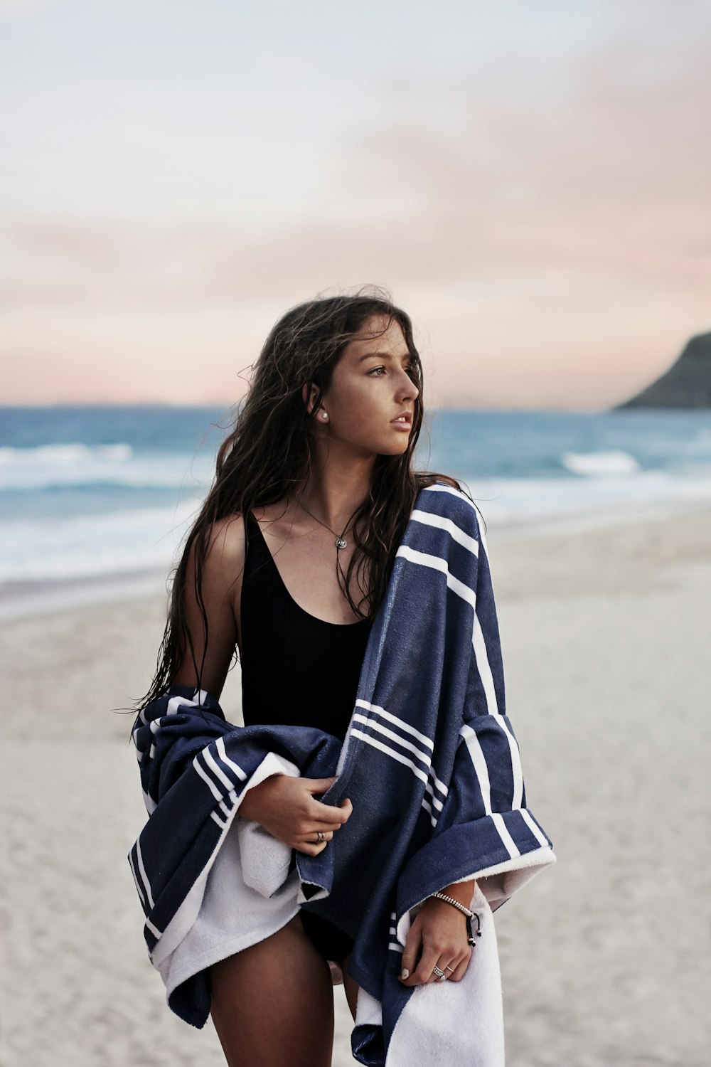 Femme portant un monokini et debout sur le bord de la mer