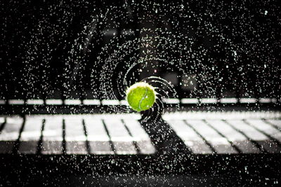 A dynamic shot of a baseball mid-air against a dark background with blue accent lighting.