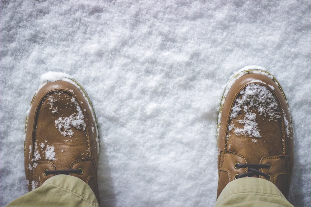 top view photography of person standing on snow covered field