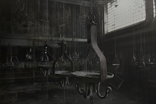 A dimly lit room with leather textures and chains hanging, evoking a mysterious BDSM atmosphere.