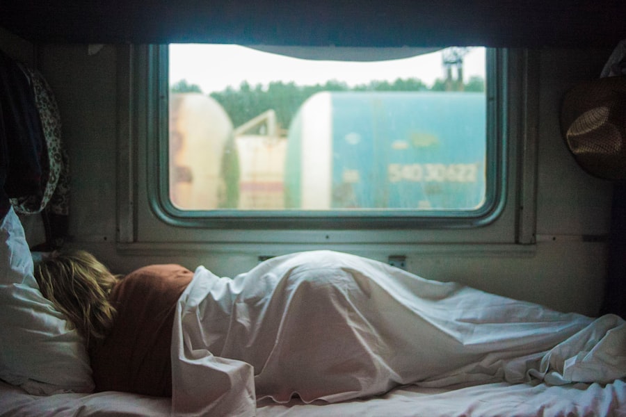 A traveller asleep on the move, head against a window mid-journey