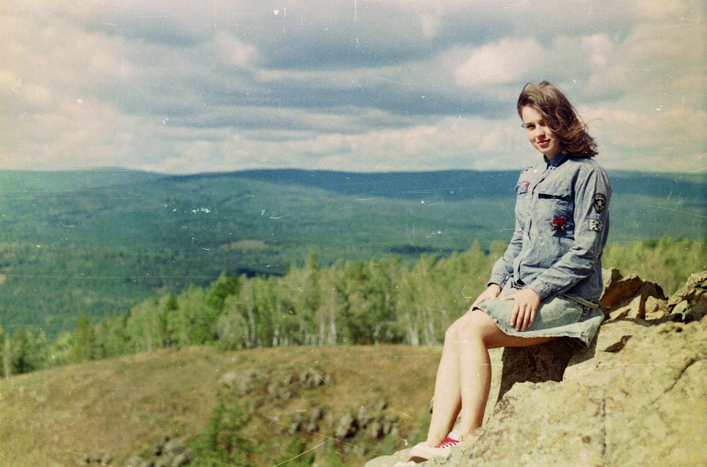 woman sitting on stone during daytime