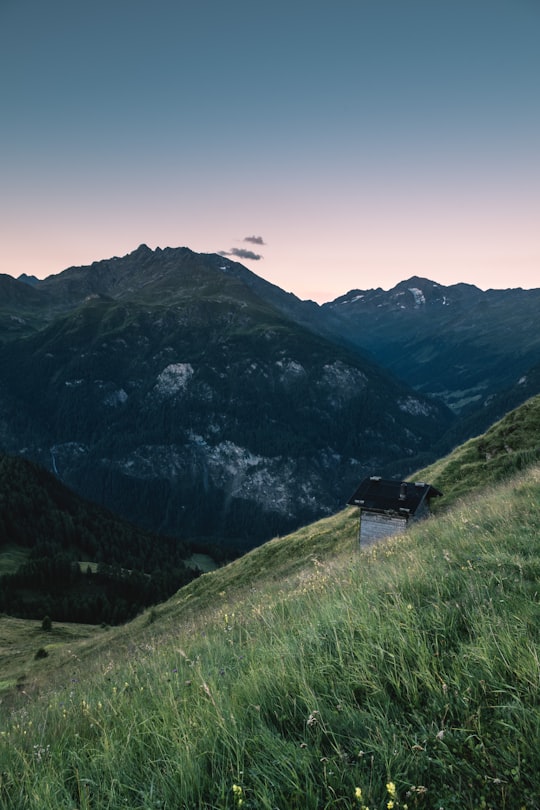 black roof house on green grass field at daytime in Grossglockner High Alpine Road Austria
