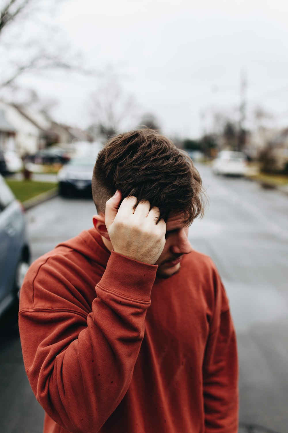 man walking on road with left hand on head