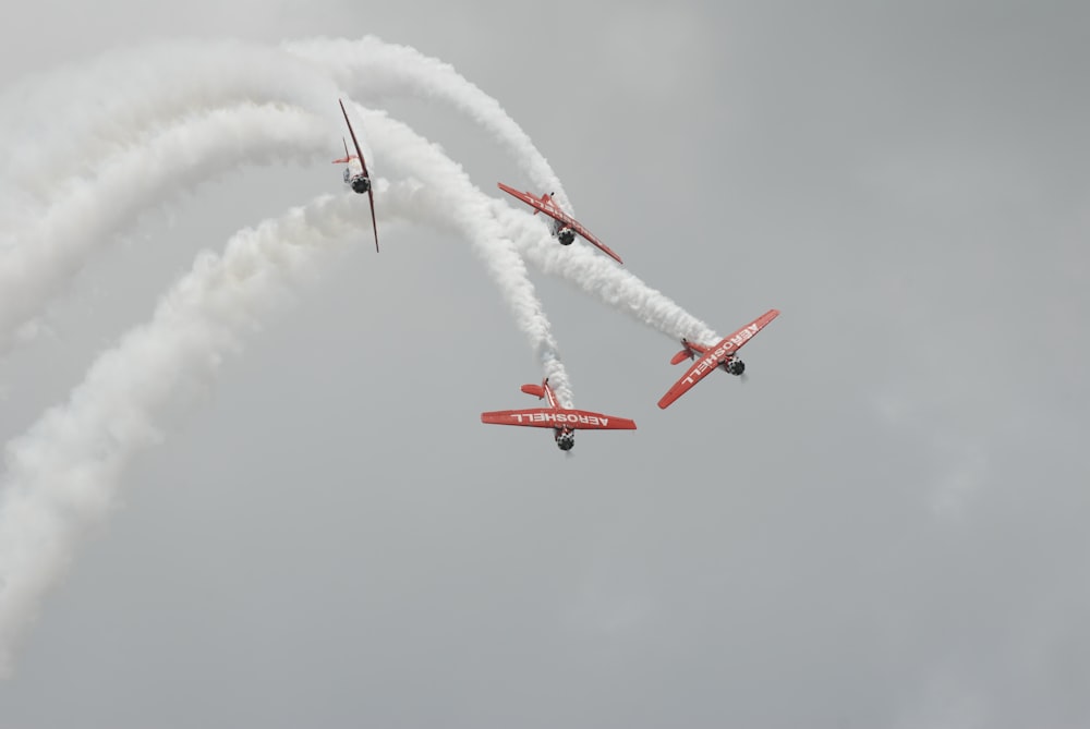 Exposição aérea de quatro biplanos vermelhos