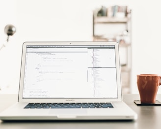 MacBOok Pro beside brown mug