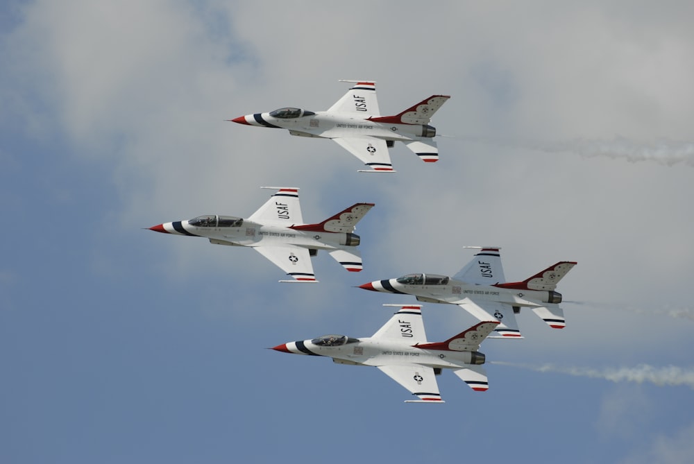 four white jet planes flying during daytime