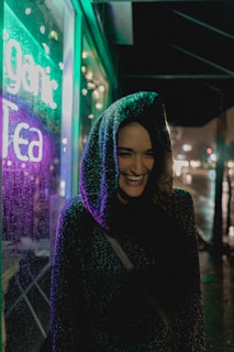 A smiling customer wearing a Lumina Apparel jacket, standing on a bustling urban street.