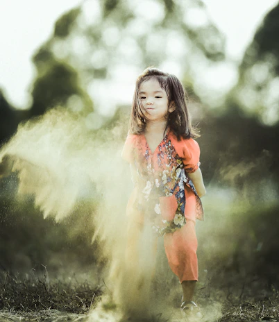 A smiling child twirling in a flexty dress with playful patterns.