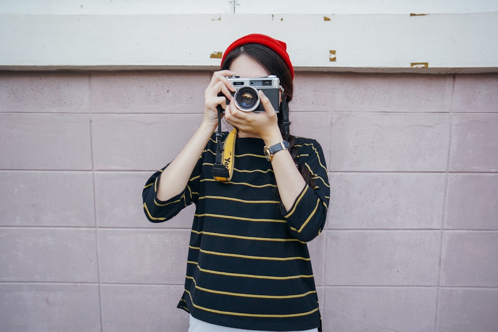 mulher segurando a câmera DSLR enquanto tira foto