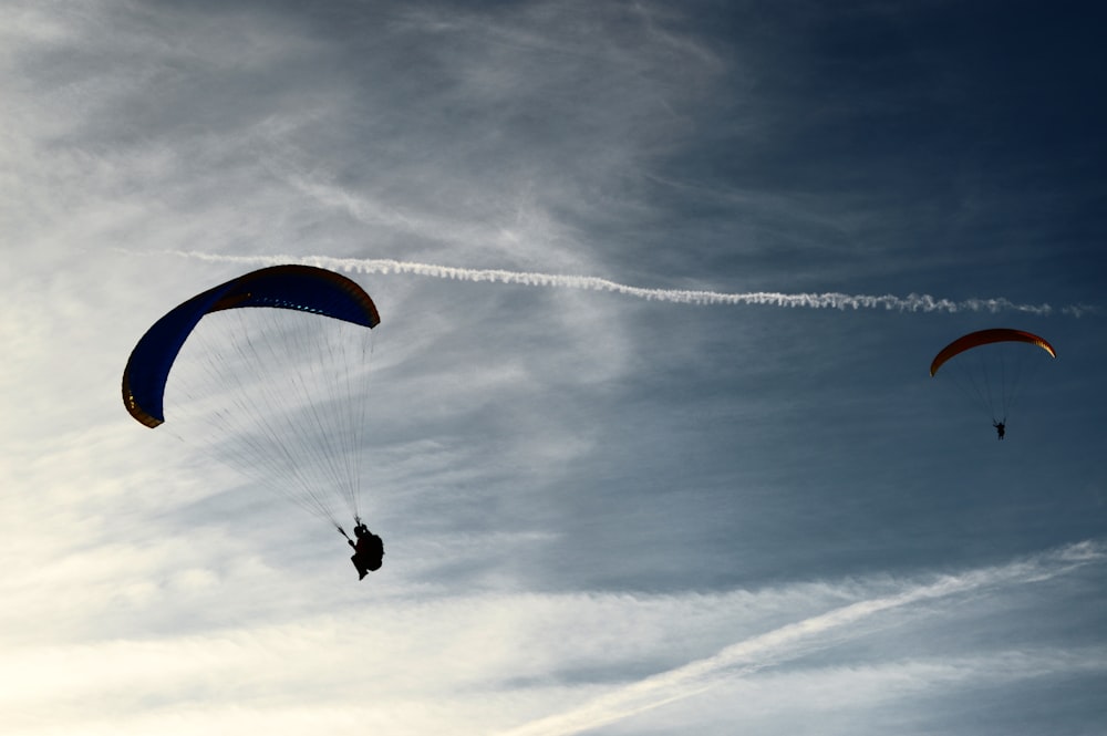 zwei Personen reiten tagsüber mit dem Fallschirm auf Wolken