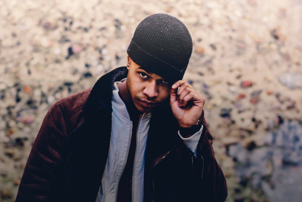 Photo de mise au point sélective d’un homme portant un manteau et un bonnet bruns