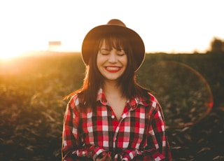 golden hour photography of woman in red and white checkered dress shirt