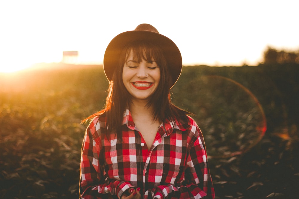 golden hour photography of woman in red and white checkered dress shirt