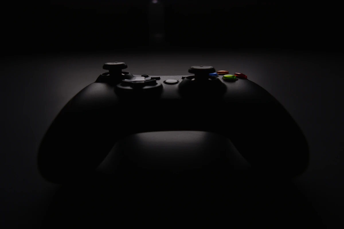 Une manette Xbox noire photographiée de près, sur un fond flou