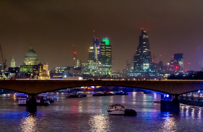 Night view of London’s iconic landmarks lit up, with people connected on their devices.