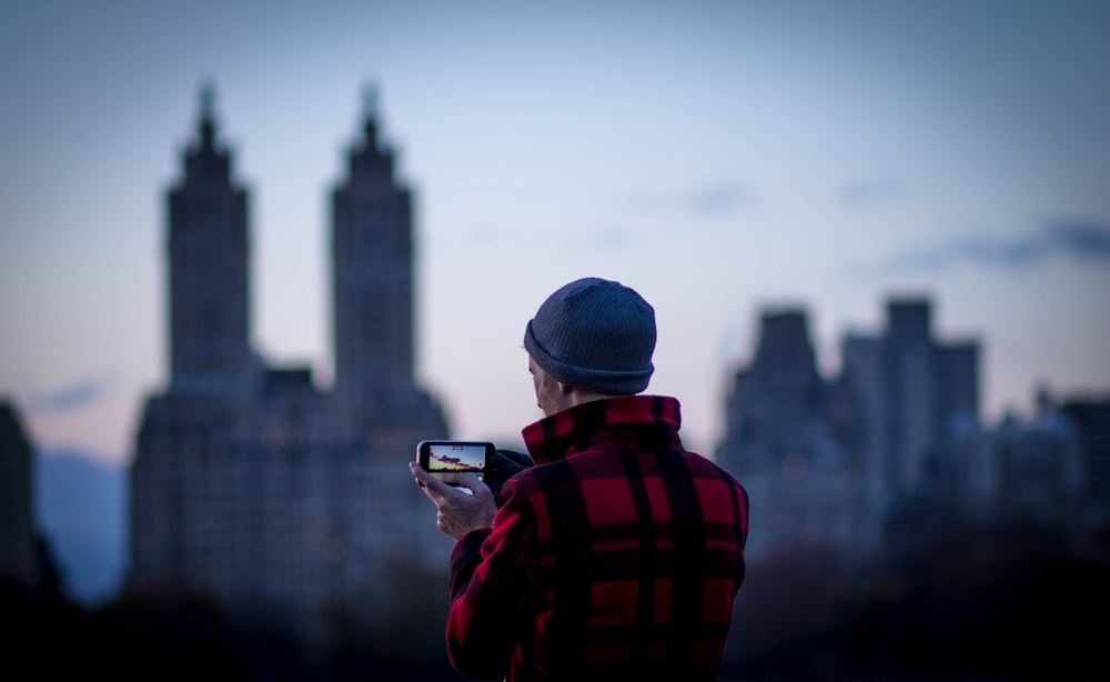 person taking a picture of city at daytime