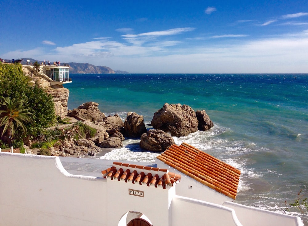 white and brown concrete building near sea during daytime