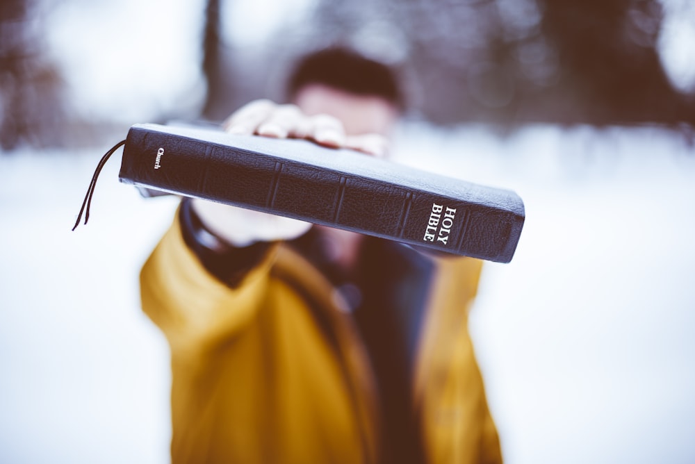 person holding Holy Bible