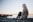 woman sitting on gray dock near bpdy of water